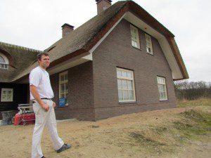 Peter Jan van Doorn voor de villa die hij aan het afwerken is. Zodra ze binnen klaar zijn gaan ze, voor de tuinarchitect uit, de buitenkant doen