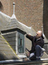 Harry Jansen van Ridder Schilders schildert één van de koepeltjes van de kerk in Bredevoort. Niet zichtbaar op de foto: de steiger tegen de ingesteigerde gevel van de kerk,vlak achter hem