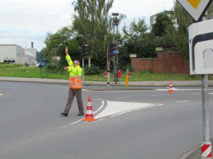 De verkeersregelaar wijst verkeersdeelnemers heel beslist de weg 